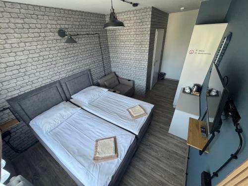 a bedroom with a bed and a brick wall at Guest Apartments Orłowo in Gdynia