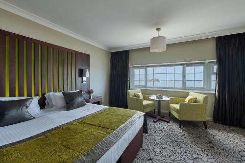 a hotel room with a bed and a table and chairs at Grand Jersey Hotel and Spa in Saint Helier Jersey