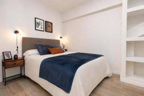 a bedroom with a large bed with a blue blanket at Xena Cucuraza by BeValle in Panticosa