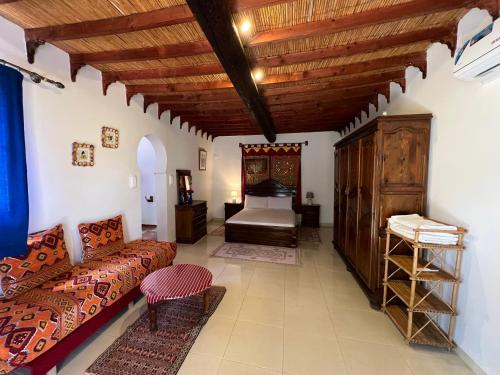 a living room with a couch and a bed at Rayani Maison d'Hôtes in Chozas
