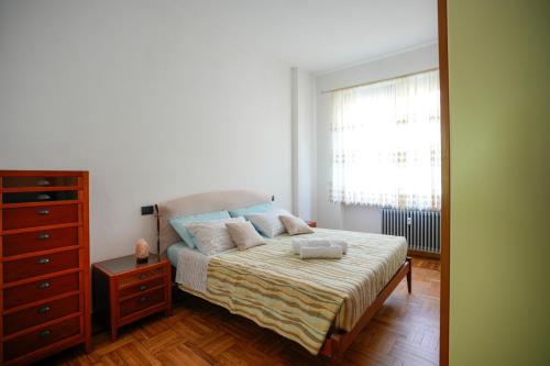 a bedroom with a bed with a dresser and a window at Casa di Caterina in Cuneo