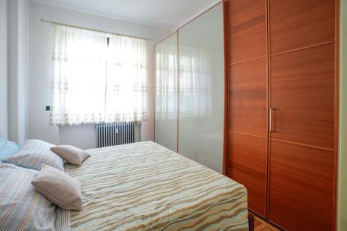 a bedroom with a bed and a wooden cabinet at Casa di Caterina in Cuneo