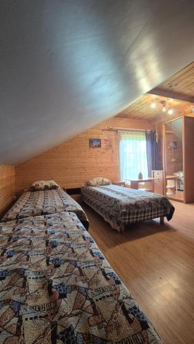 a room with two beds in a room with at Kupiškio marių vila in Aukštupėnai
