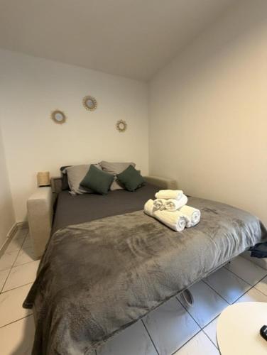 a bedroom with a bed with two towels on it at Saint-Pierre Studio in Avignon