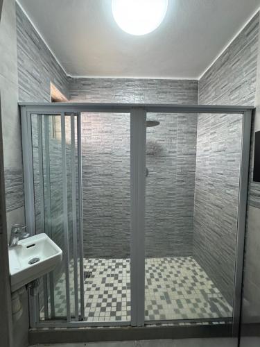 a shower with a glass door and a sink in a bathroom at Afsaal 612 in Amanzimtoti