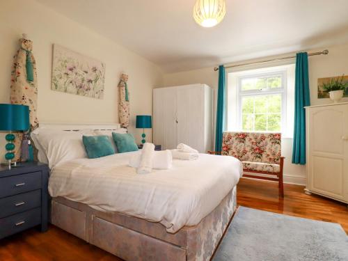 a bedroom with a large bed with blue curtains at Vis Valley View in Pentewan