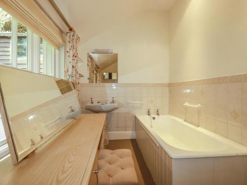 a bathroom with a tub and a sink at Vis Valley View in Pentewan