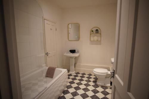 a bathroom with a toilet and a sink at Garden Seafront Flat Hastings in Hastings