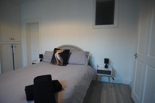 a bedroom with a white bed with two pillows at Garden Seafront Flat Hastings in Hastings