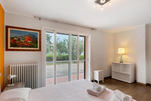a bedroom with a bed and a large window at Villa Capo Berta View in Diano Marina