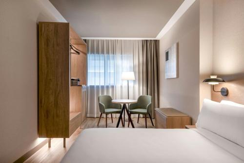 a hotel room with a bed and a table and chairs at AC Hotel Atocha by Marriott in Madrid