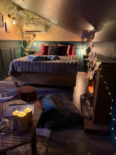 a bedroom with a bed and a table with candles at Le grenier des sorciers in Balbigny