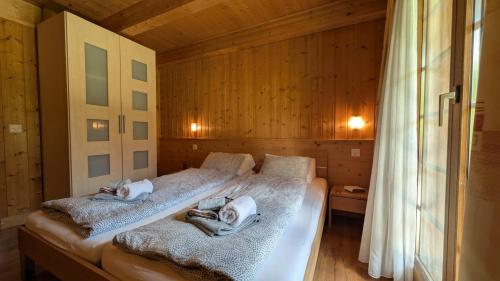a bedroom with two beds with towels on them at Chalet Veronique Private Sauna & FREE SaastalCard in Saas-Fee