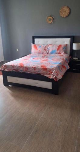 una camera da letto con un letto con un piumone sopra di Cuic apart a Cabinda
