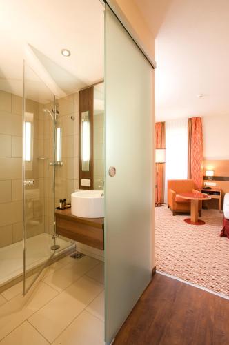 a bathroom with a shower and a sink at TaunusTagungsHotel in Friedrichsdorf
