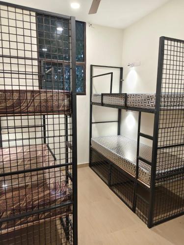 a room with three bunk beds and a window at Kerala dormitory edapally in Cochin
