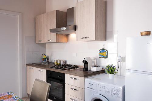 a kitchen with a stove top oven next to a refrigerator at A un Passo dal Centro in Modica