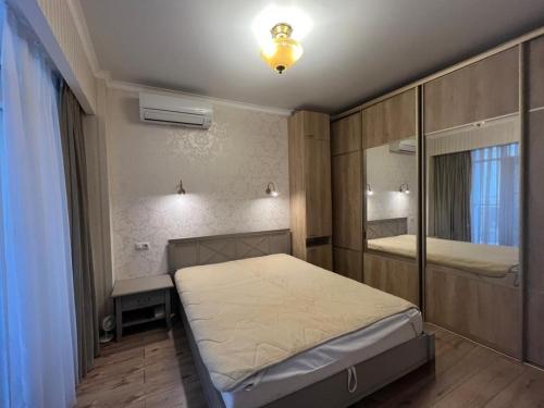 a small bedroom with a bed and a mirror at Guest Apart in Ozurgetʼi