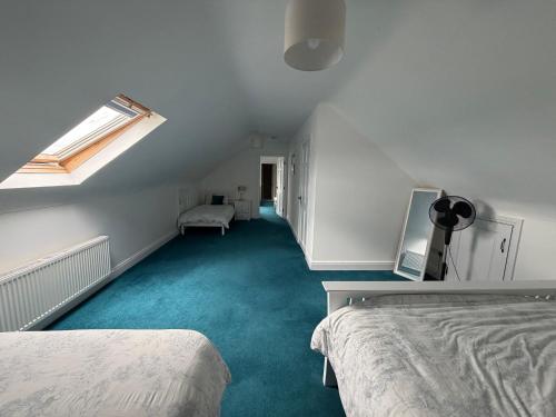 a attic room with two beds and a window at Cosy East Clare Apartment in Coolcoosaun
