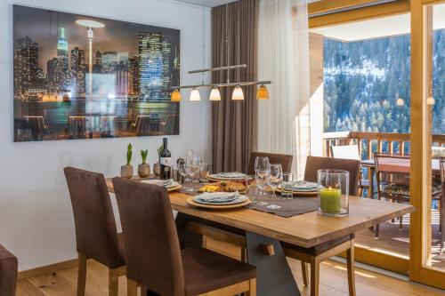 a dining room with a wooden table and chairs at Chalet Les Rahâs by Mrs Miggins in Grimentz