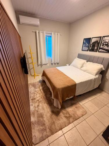 a bedroom with a bed and a window at Apart Centro 06 in Tubarão