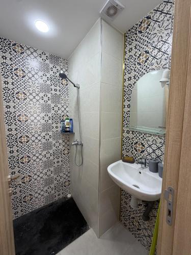 a bathroom with a sink and a shower with a mirror at Apartment with pool in Asilah