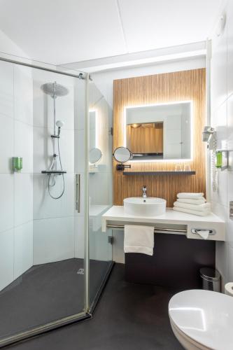 a bathroom with a shower and a sink and a toilet at Hotel Woudschoten in Zeist