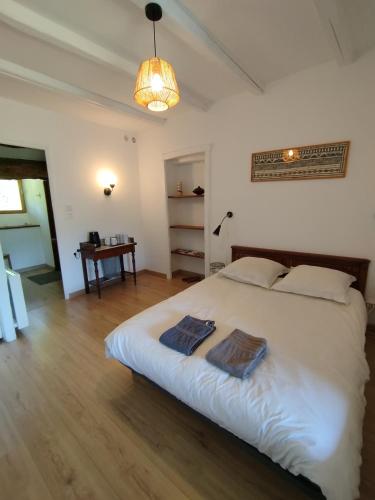 a bedroom with a large bed with two towels on it at La Bouriotte Chambre d'hôtes Bouton D'Or in Labastide-Rouairoux