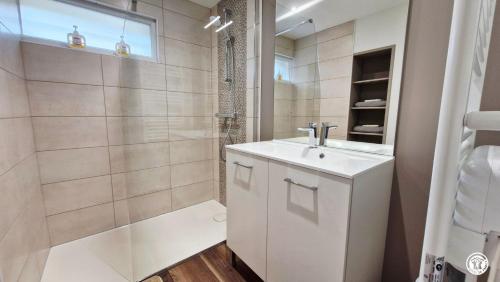 a white bathroom with a sink and a shower at La Virée Champêtre in Villiers-Saint-Benoît