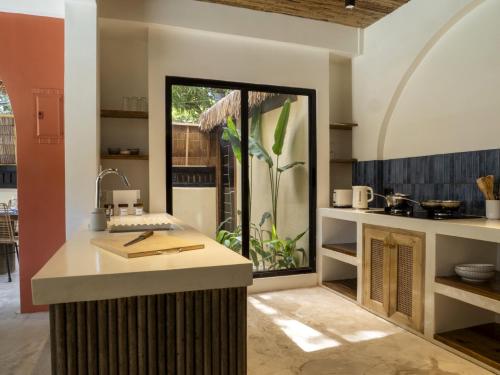 a kitchen with a counter and a large window at DILAW Villa avec piscine privée in El Nido