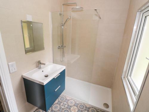 a bathroom with a sink and a shower at Mayfly Cottage in Clonbur