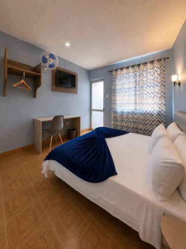 a large bedroom with a large bed and a desk at Pensão Asa Branca in Assomada