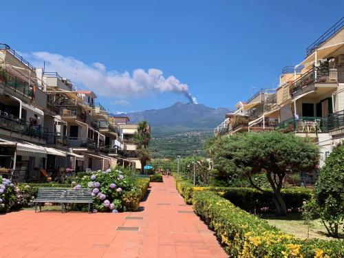 a street with a bench and a mountain in the background at Crateri e coralli in Mascali