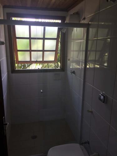 a bathroom with a toilet and a window at Flats Vila Vitoria Residencial in Camburi