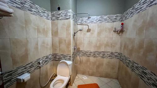a bathroom with a toilet and a shower at Lush Garden Hotel in Arusha