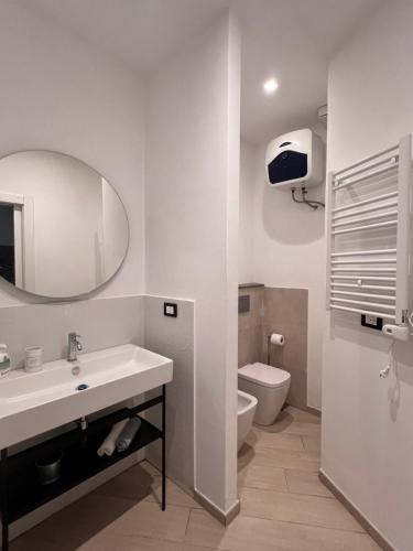 a white bathroom with a sink and a toilet at Casa Acquarello in Savona