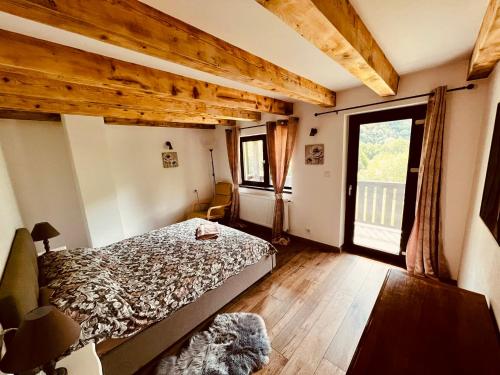 a bedroom with a bed and a large window at La Izvoare in Clopotiva