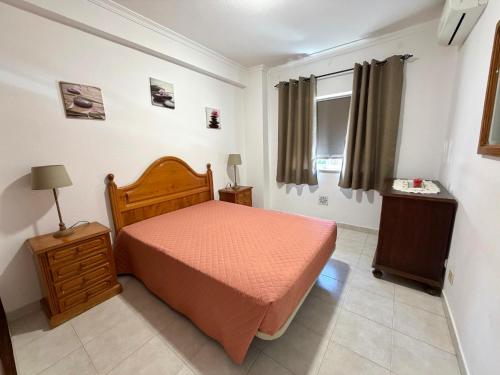 a small bedroom with a bed and a window at Edificio Canoa in Armação de Pêra