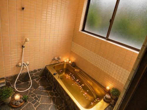 a bath tub in a bathroom with a window at Villa Amoria Ocean View in Miyazaki