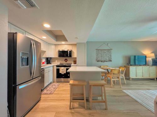 a kitchen with a refrigerator and a table with chairs at Vacation Villas #432 - Beachfront Condo in Fort Myers Beach