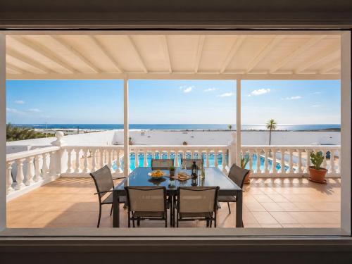 a dining room with a table and chairs on a balcony at La Ventana al Mar in Güime