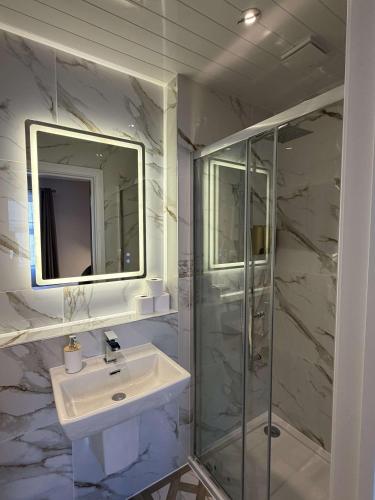 a white bathroom with a sink and a shower at Emerald Tide Hotel - Blackpool in Blackpool