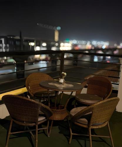 Ein Tisch und Stühle auf einem Balkon bei Nacht in der Unterkunft KH Hotel in New cairo