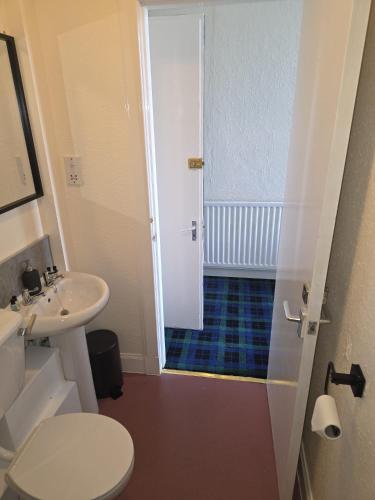 a small bathroom with a toilet and a sink at Waverley Hotel in Bonnyrigg