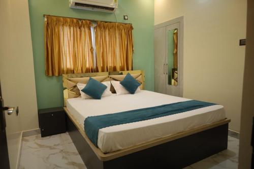 a bedroom with a bed with blue pillows and a window at Hotel RK Royale in Patna
