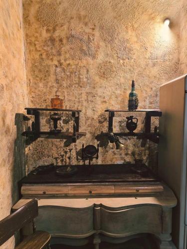 a room with a stone wall with a sink and shelves at Etno kuća Teodora in Staji°evo