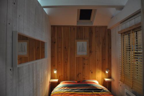 a bedroom with wooden walls and a bed with lights at La Cabane 14 climatisée - Escapade sur le Bassin d'Arcachon - Terrasse & Nature in Lanton
