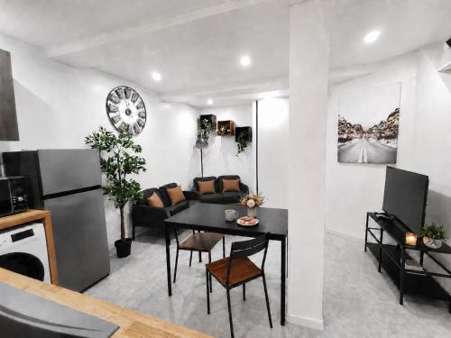 a kitchen and living room with a table and a couch at Le temps d'une pause -4- in Cepoy