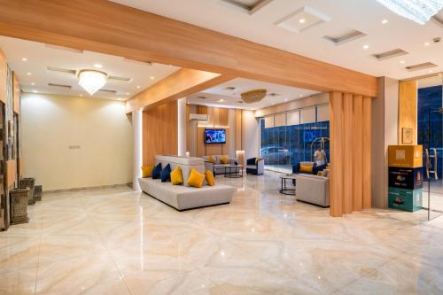 a living room with couches and a tv on a wall at AlQasr - Almansak in Abha