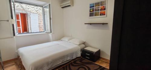 a small bedroom with a bed and a window at Medin BD in Budva